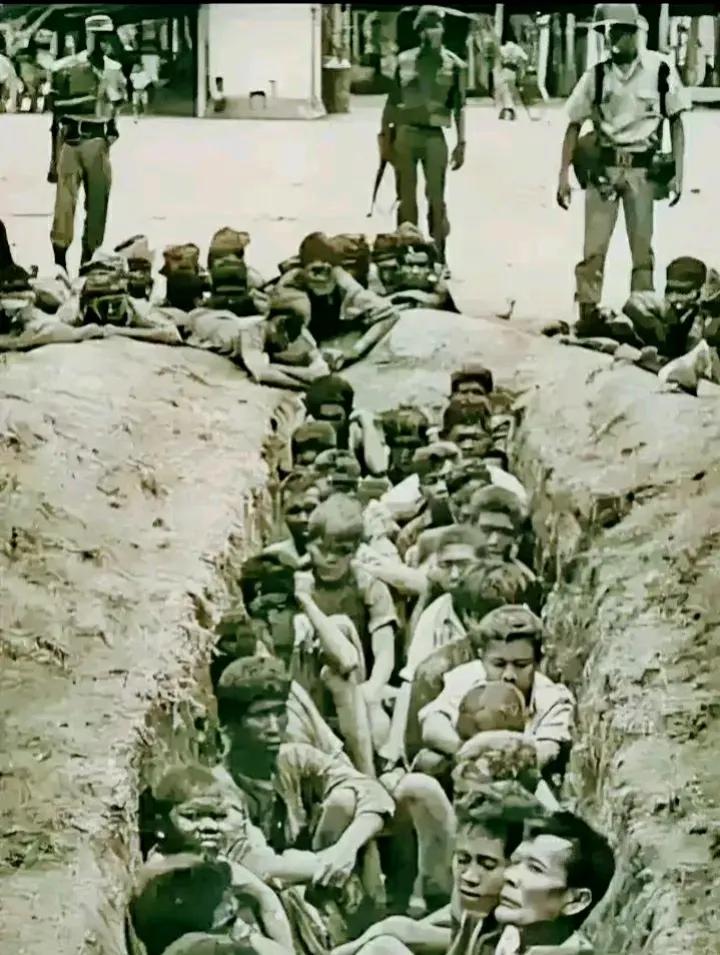 1965年，印尼街头，这是一张令人痛心的照片，三名军警荷枪实弹，把一群无辜的华人