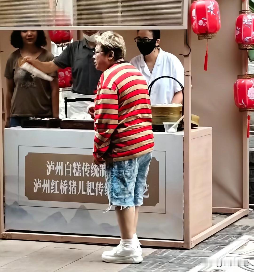 韩红现身泸州街头，她真人看起来好矮，身材臃肿，两条腿又短又粗，一头黄毛好难看，这