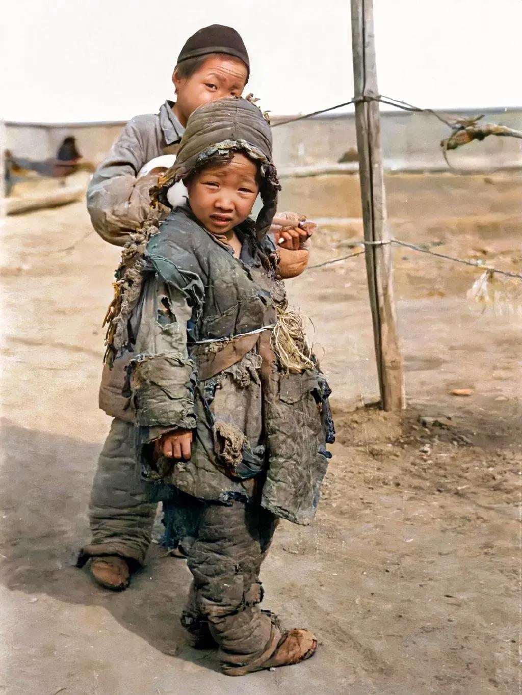 1942年，河南，两个小乞丐，照片中的他们身穿破破烂烂的衣服，让人心疼。大一点的