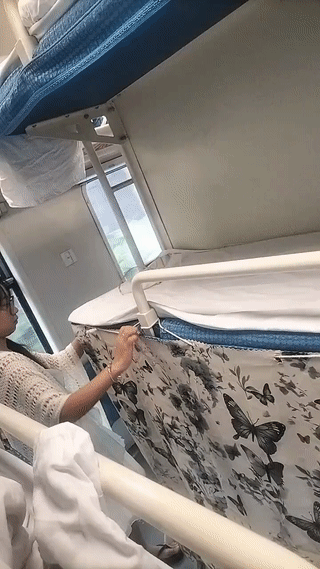 这个女孩乘坐火车卧铺。真的非常注意保护自己的隐私。
她还专门带了围帘把自己的下铺