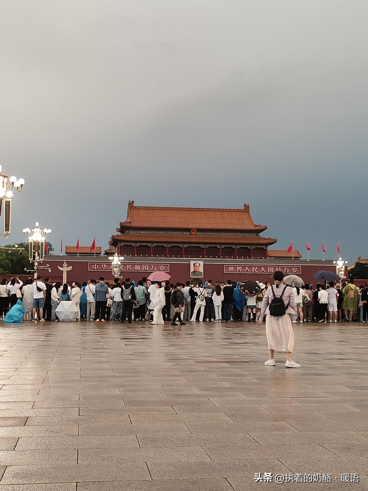 天安门广场上，雨中游客如织，感受历史与现代的交融。北京城楼夜景