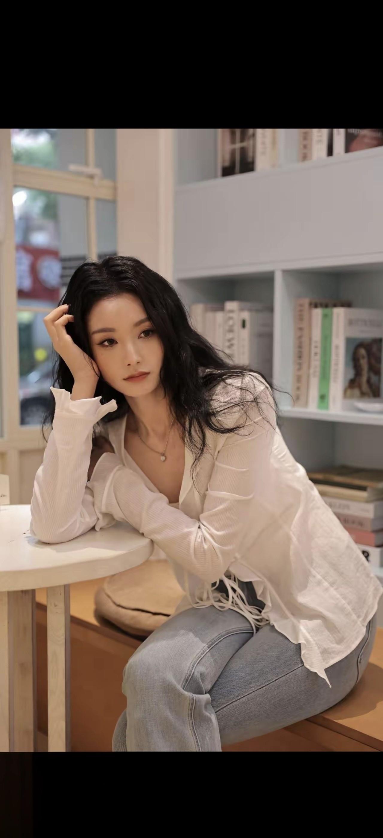 一个女孩坐在书店角落看书。