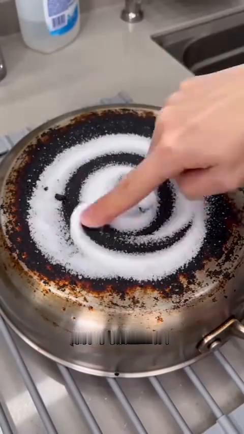 烧焦锅底的清洁妙招。
把食盐和小苏打撒在烧糊的锅底，涂抹均匀后盖上纸巾，再倒上白