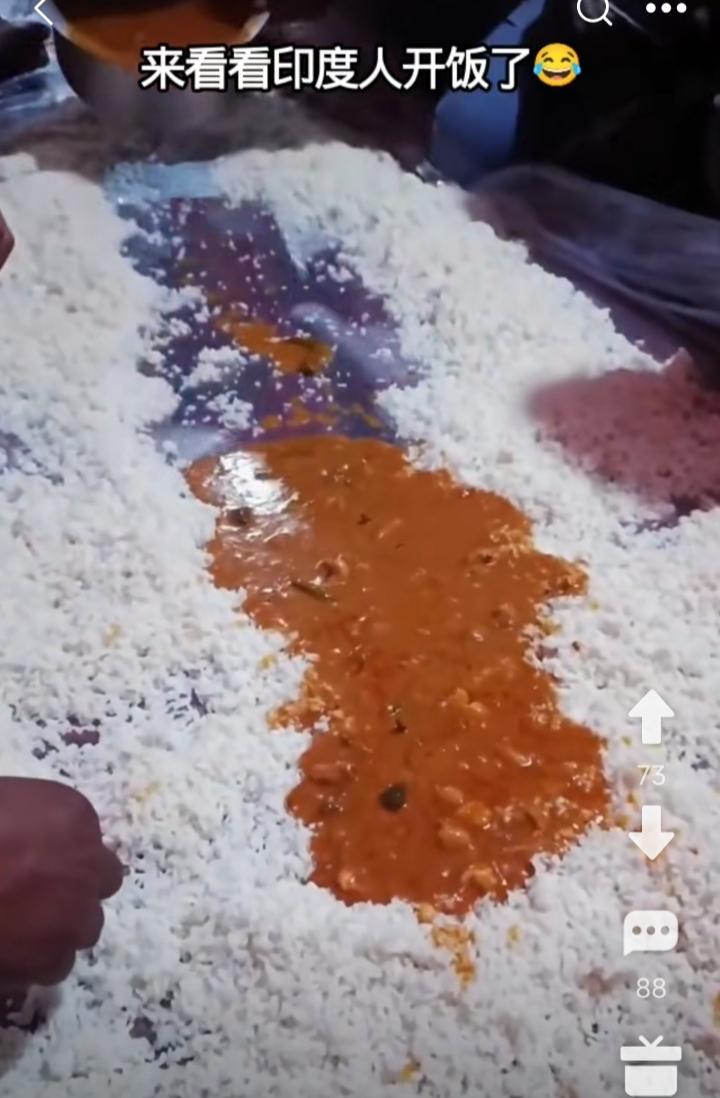 印度人开饭了。
一群人席地而坐，把大米饭铺在胶布上，再淋上黄中带黑的咖喱酱，然后