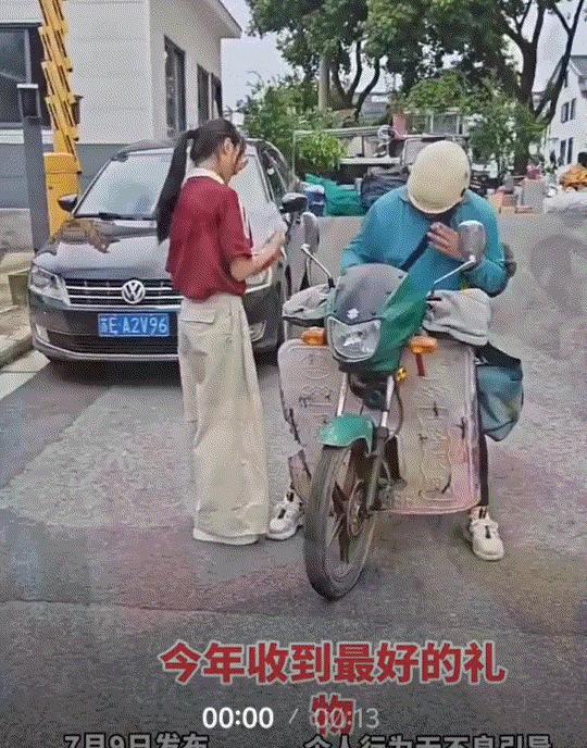 一快递员为女生送来高考录取通知书，而女生下来拿通知书时，为了分享自己这份金榜题名