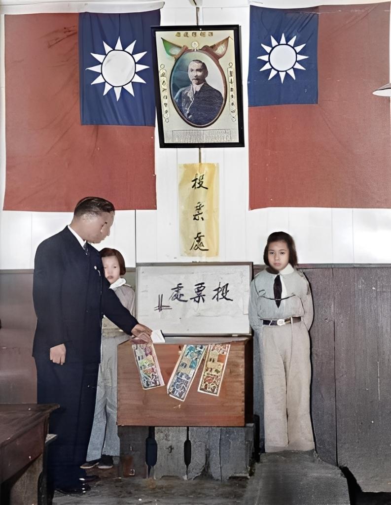 这张照片拍的是1947到1948年那会儿的选举场景。画面里，墙上挂着两面带有青天
