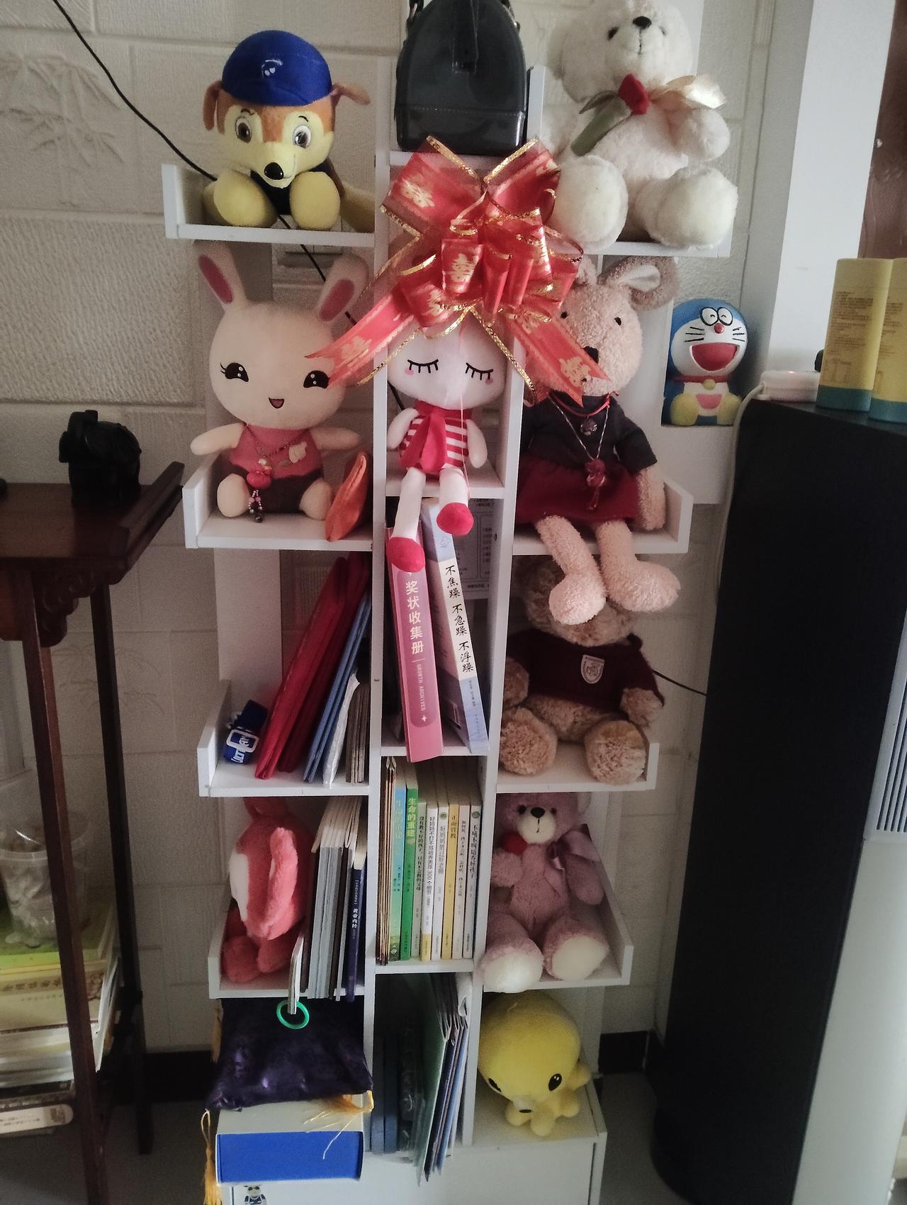每次看到这个摆满玩偶和书籍的角落，我都觉得心里软乎乎的。这哪儿是个普通的置物架啊