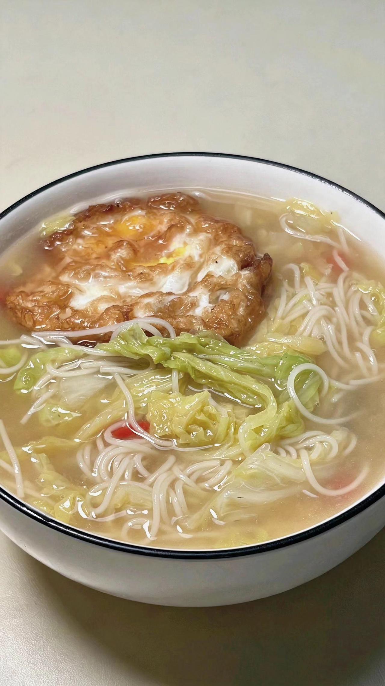 🍜煎蛋沉在汤里，像太阳落进银河✨。白菜丝儿在面间游，平凡日子也能鲜掉眉！