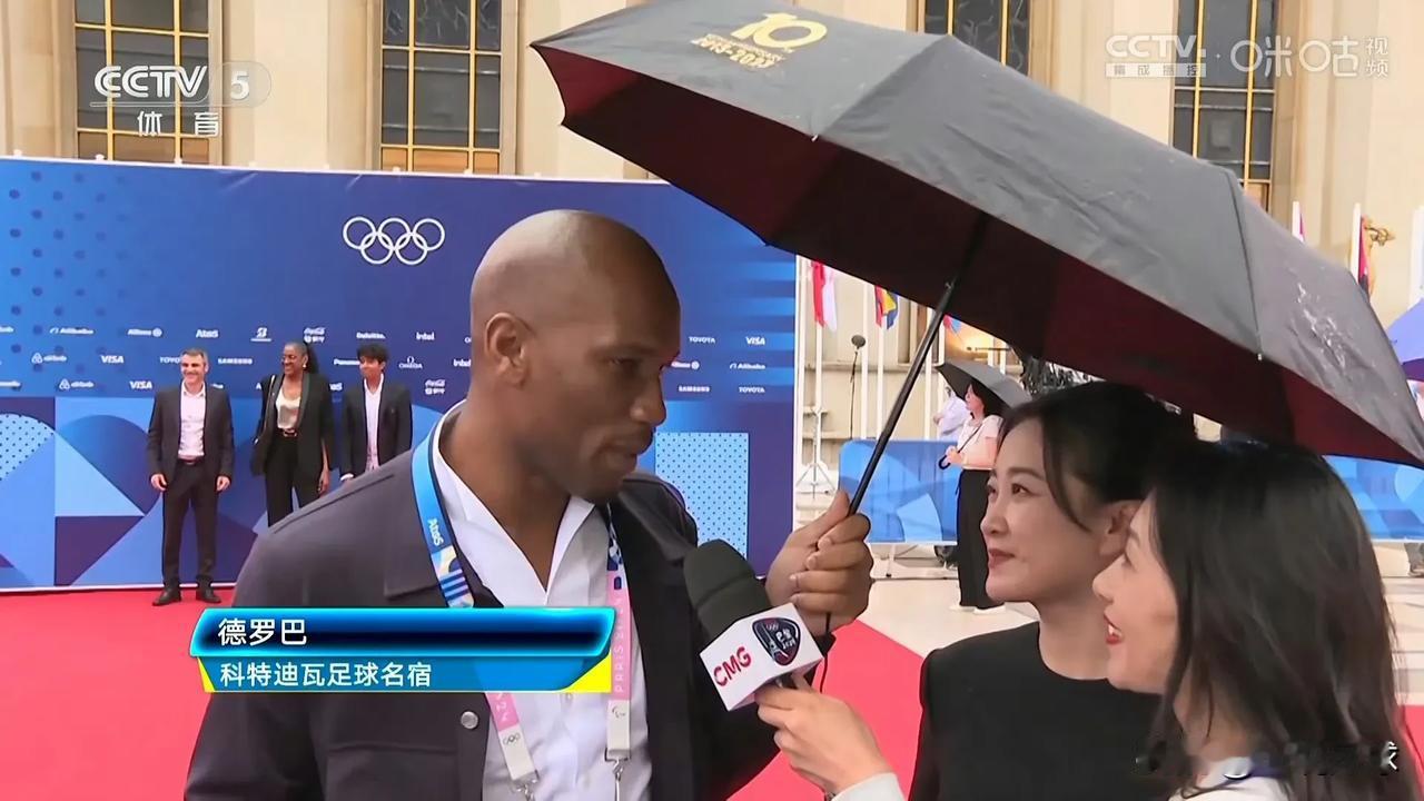 这也算是梦幻联动了！切尔西名宿德罗巴在接受媒体采访时为贾玲撑伞，有一说一，这个角