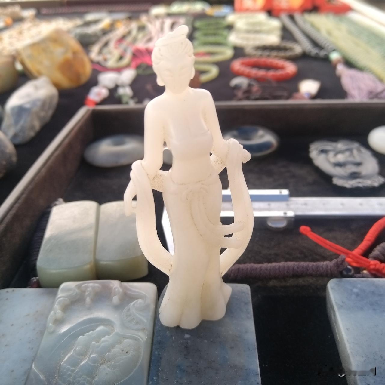 精选和田白玉雕琢而成，质地温润，白度匀净。仕女身姿端雅，眉目温婉，衣纹雕琢细腻灵