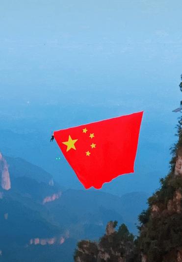 “上人民日报了！”河南云台山半山腰，游客正爬山累得喘不过气，转头撞见工作人员悬挂