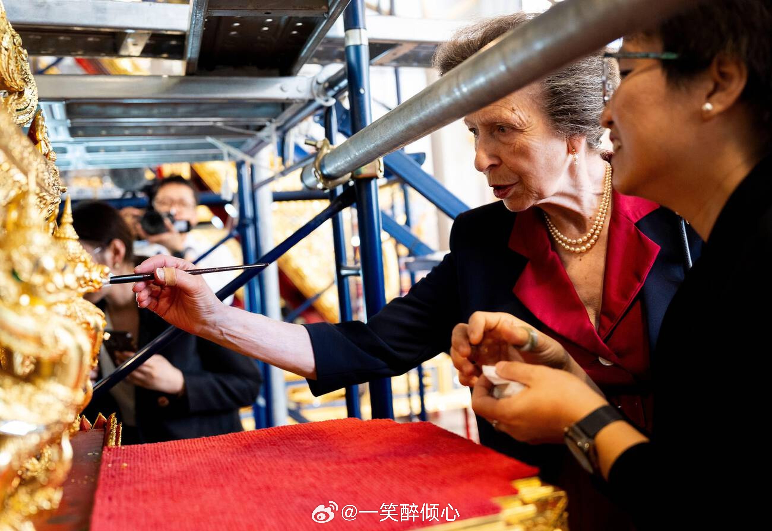 英国王室  今天安妮长公主在泰国曼谷国家博物馆为两辆泰国皇家葬礼马车涂金箔，这两