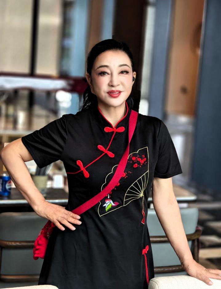 谁能一眼猜到图中人真实年纪，状态真的太惊艳！

黑底红盘扣新中式上衣搭配精致红梅