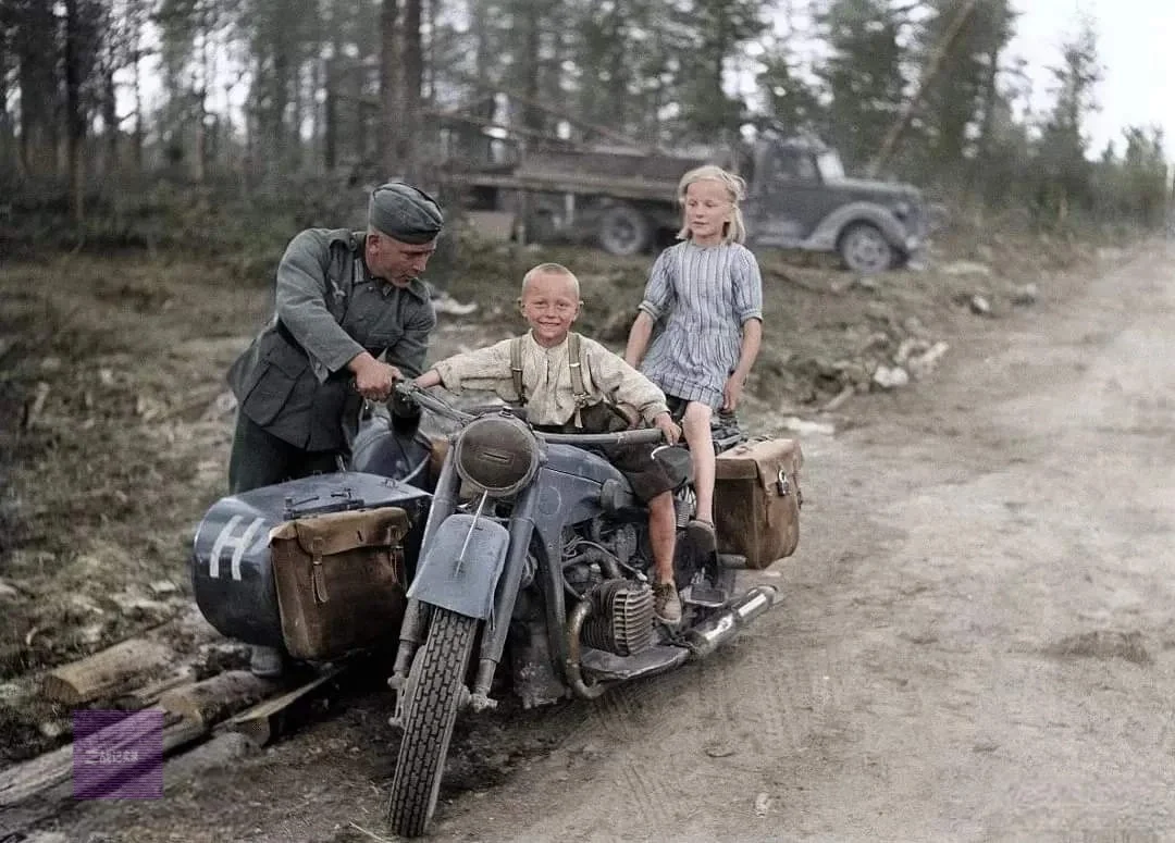 1941年7月1日，在芬兰苏奥穆斯萨尔米的道路上，一名德国士兵给当地儿...