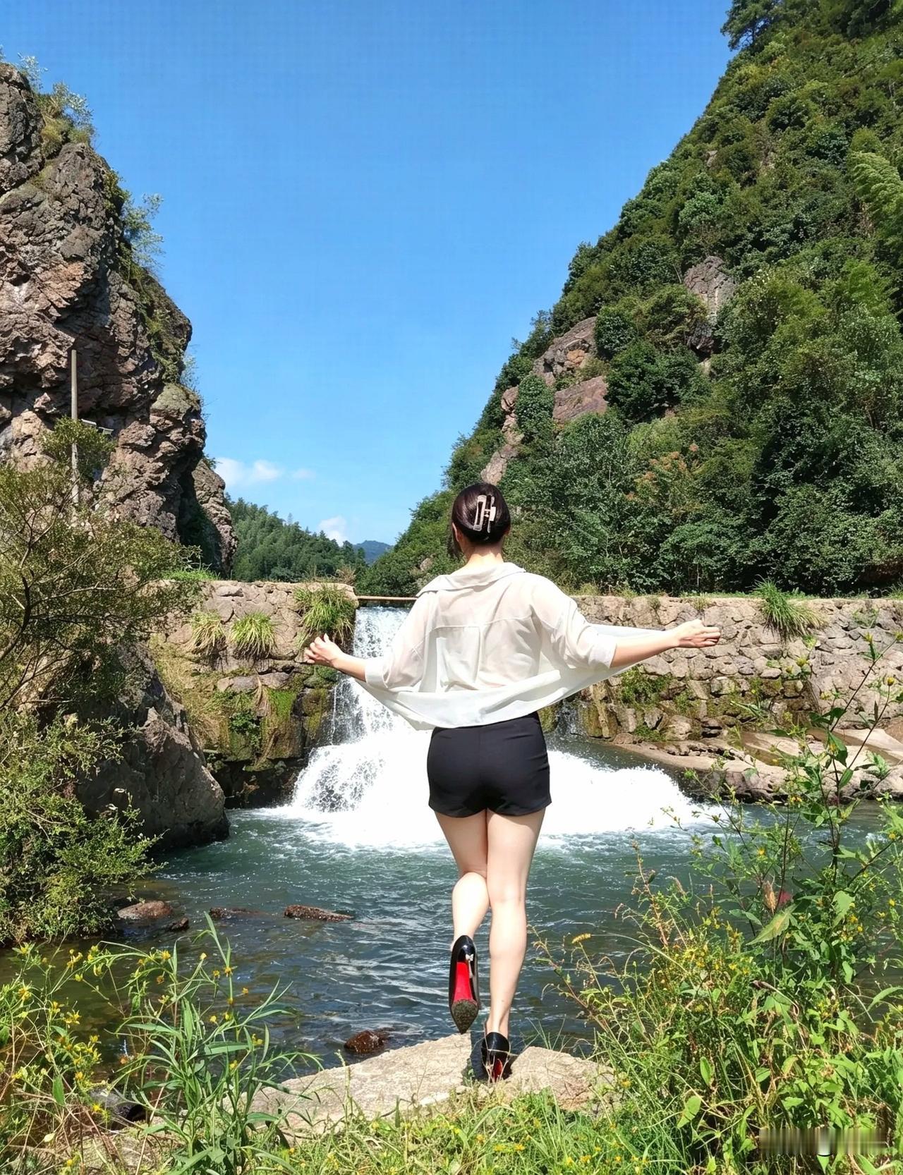 张开双臂，拥抱自然，享受美景。背影
