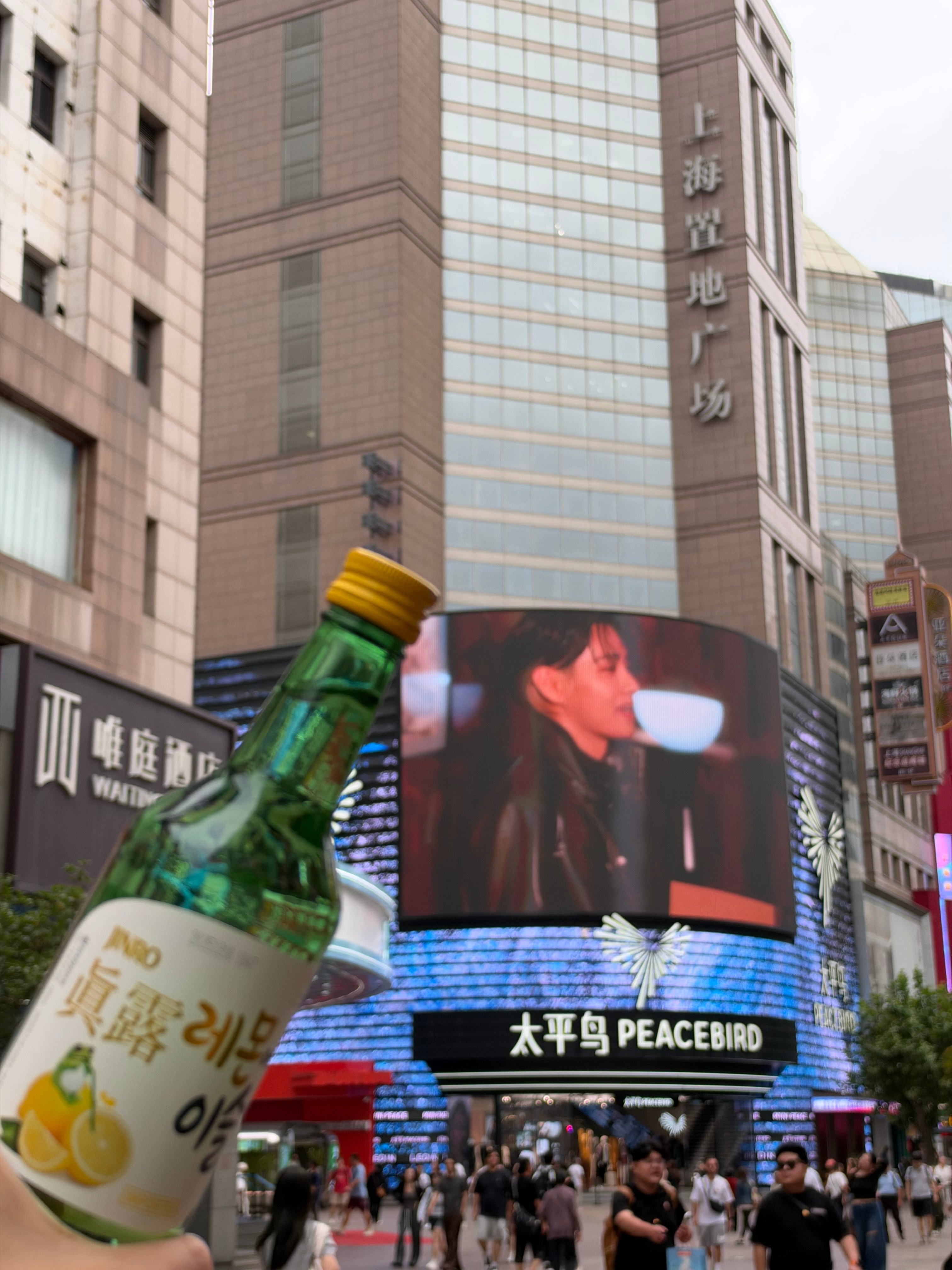 谁能拒绝上海置地这块巨型真露 V 大屏！错位拍照，举瓶同框，仿佛和 V 一起小酌