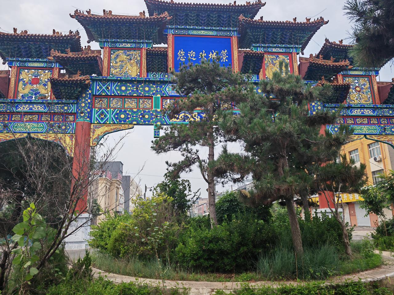 今日分享随手拍照片这座气势恢宏的牌楼，虽然被绿树遮挡，还是让人看到了这座城市的名