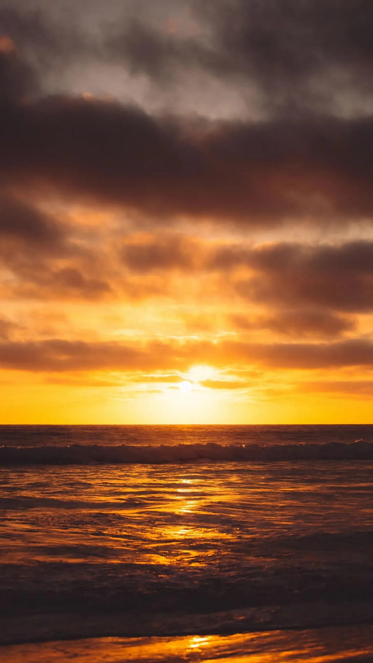 夕阳西下，海浪轻拍，宁静的海滩上洒满金色的光辉，仿佛时间在这一刻静止。#在海边拍