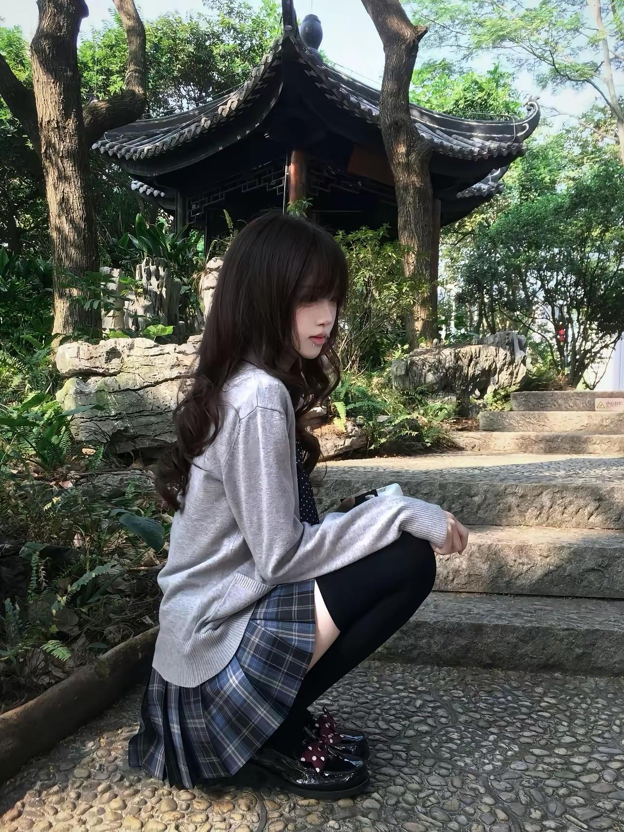 古风庭院中的少女，黑发飘逸，裙摆飞扬，静坐石阶，感受岁月静好。