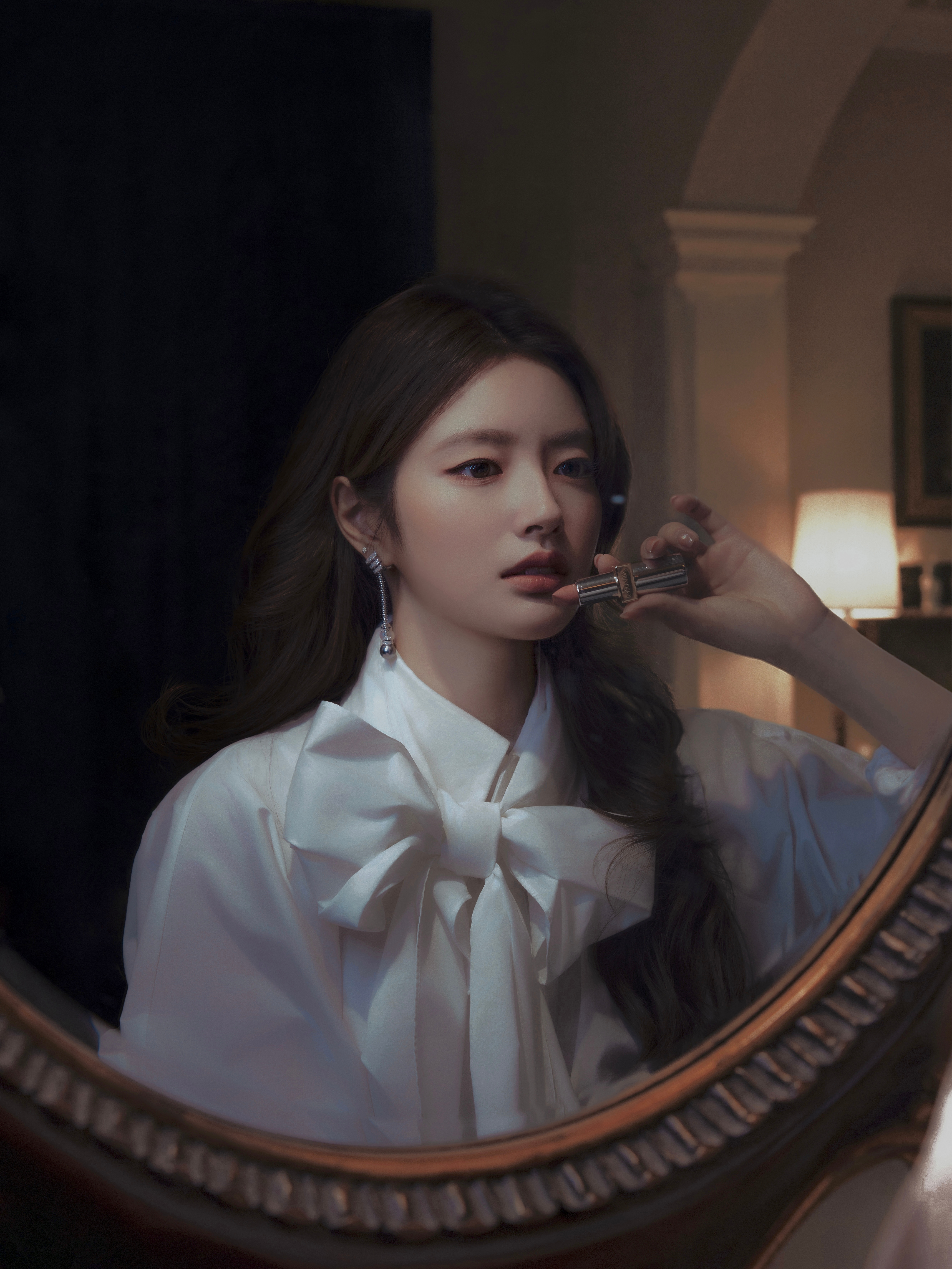 暖灯、古镜与墙上的旧画作背景，流动的光影漫过蝴蝶结与蓬纱裙摆。不必刻意演绎，一抬