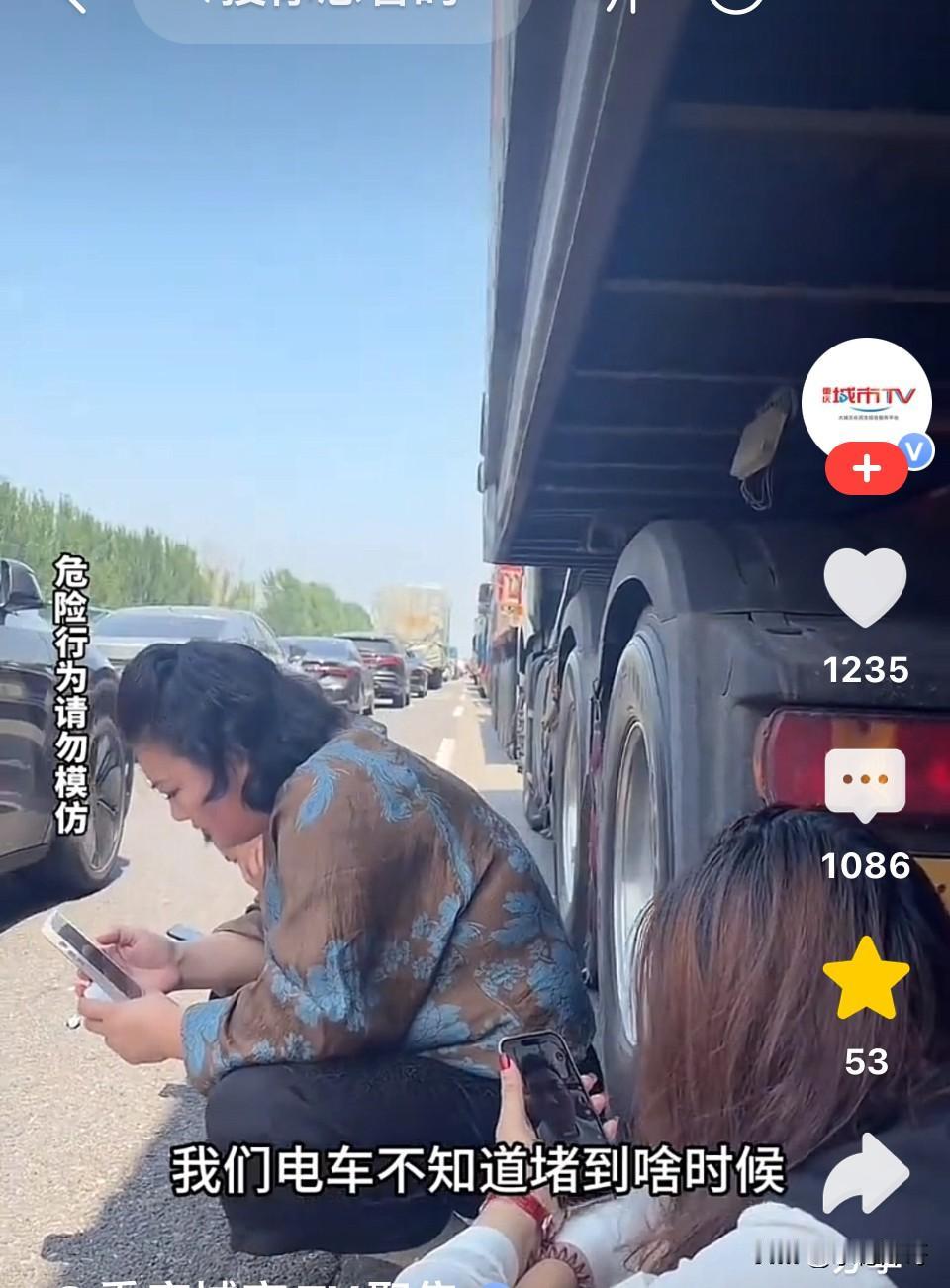 女子开着电车拉着家人出去旅行路遇堵车，怕开空调太耗电全部下车在车下等。而油车车主