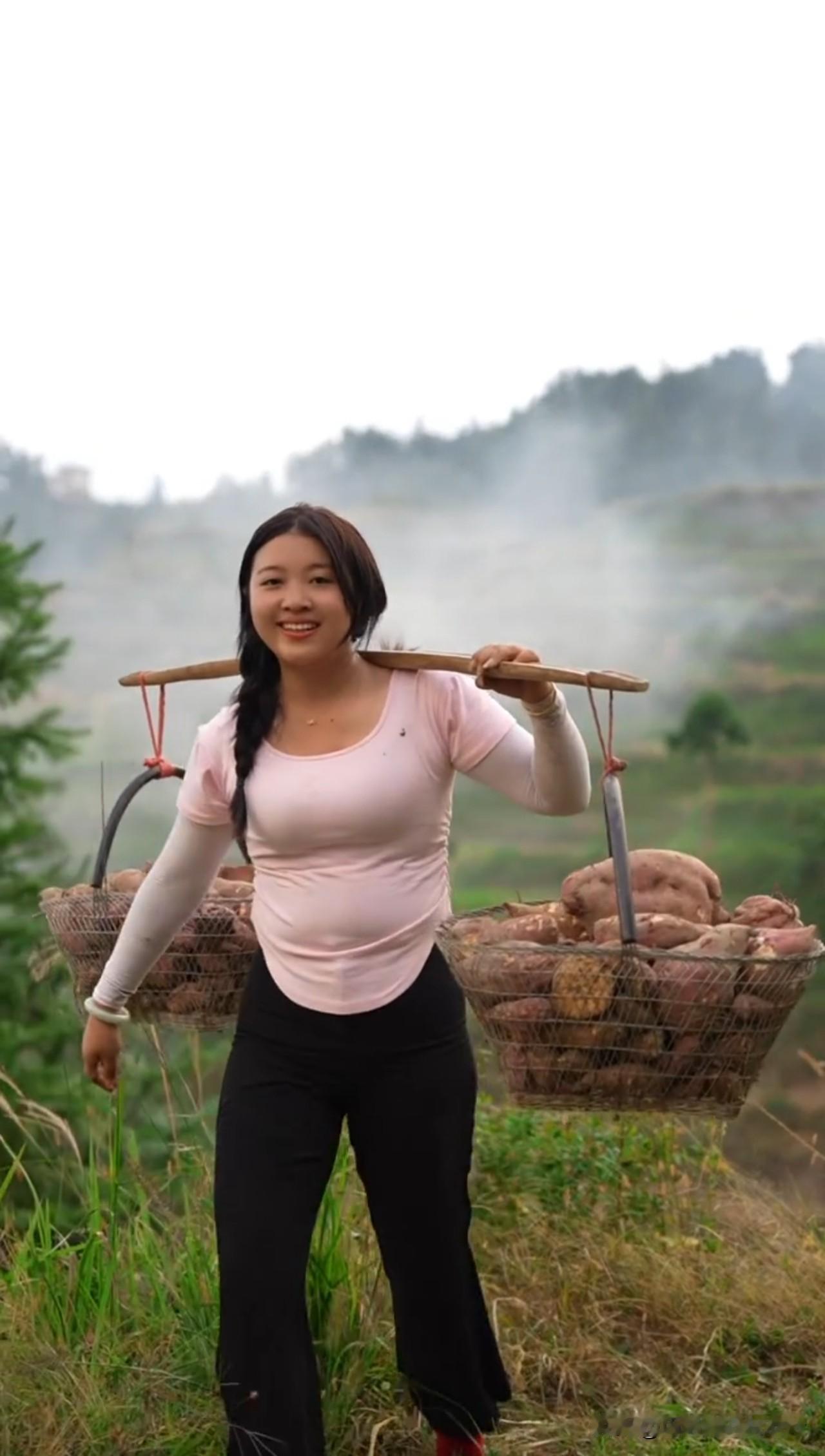 农妇挑薯赶集
 
青山叠翠雾如烟，
村妇挑薯立山间。
木担横肩沉甸甸，
两筐红芋