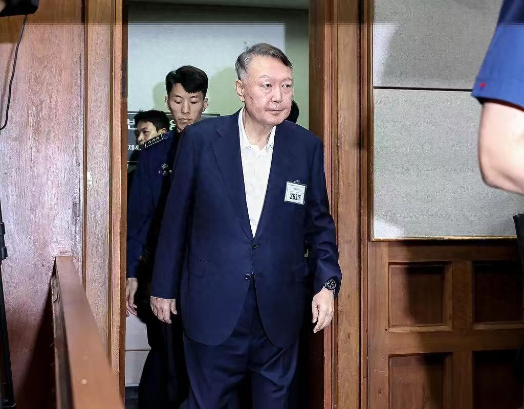 尹锡悦想换个大地方。李在明太厉害了，尹锡悦不敢再撒泼了，规规矩矩的出席了庭审，请