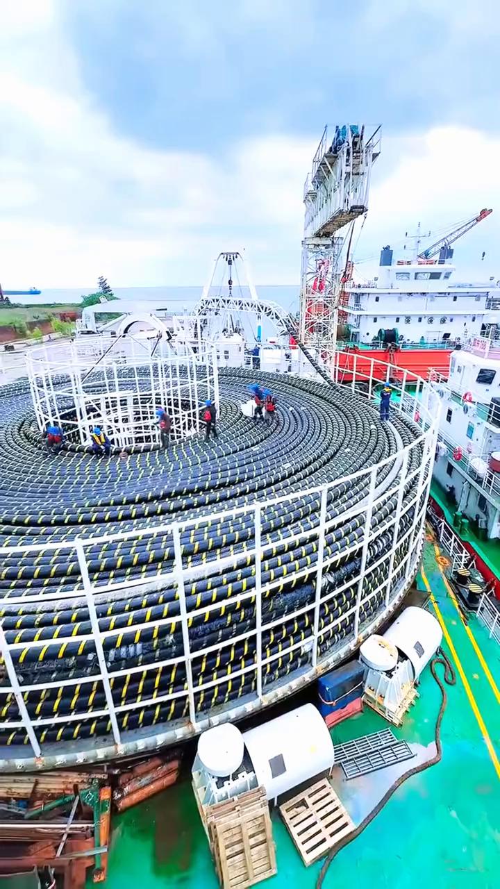 你现在看到的是一圈又一圈的海底电缆，正在被从陆地工厂有序的铺设到船上。因为这种电