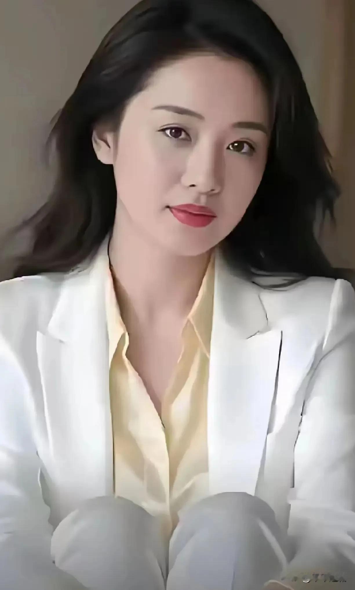 白西装裹着利落的柔，鹅黄衬得唇色更明。发梢轻晃时，连空气都浸了点从容的亮。
 