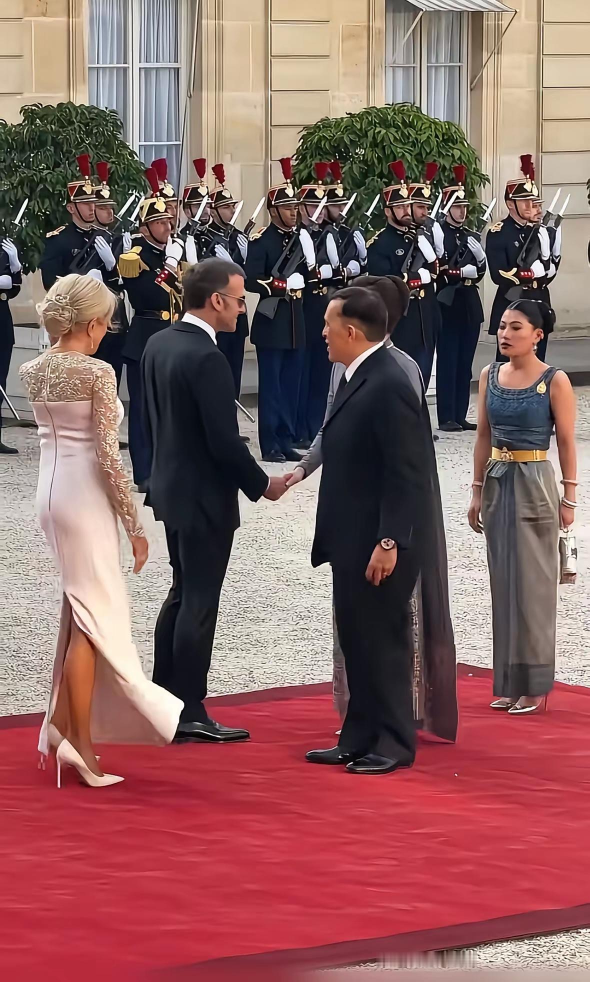 这张照片拍摄于法国巴黎爱丽舍宫的庭院内，记录了法国总统马克龙与法国第一夫人布丽吉