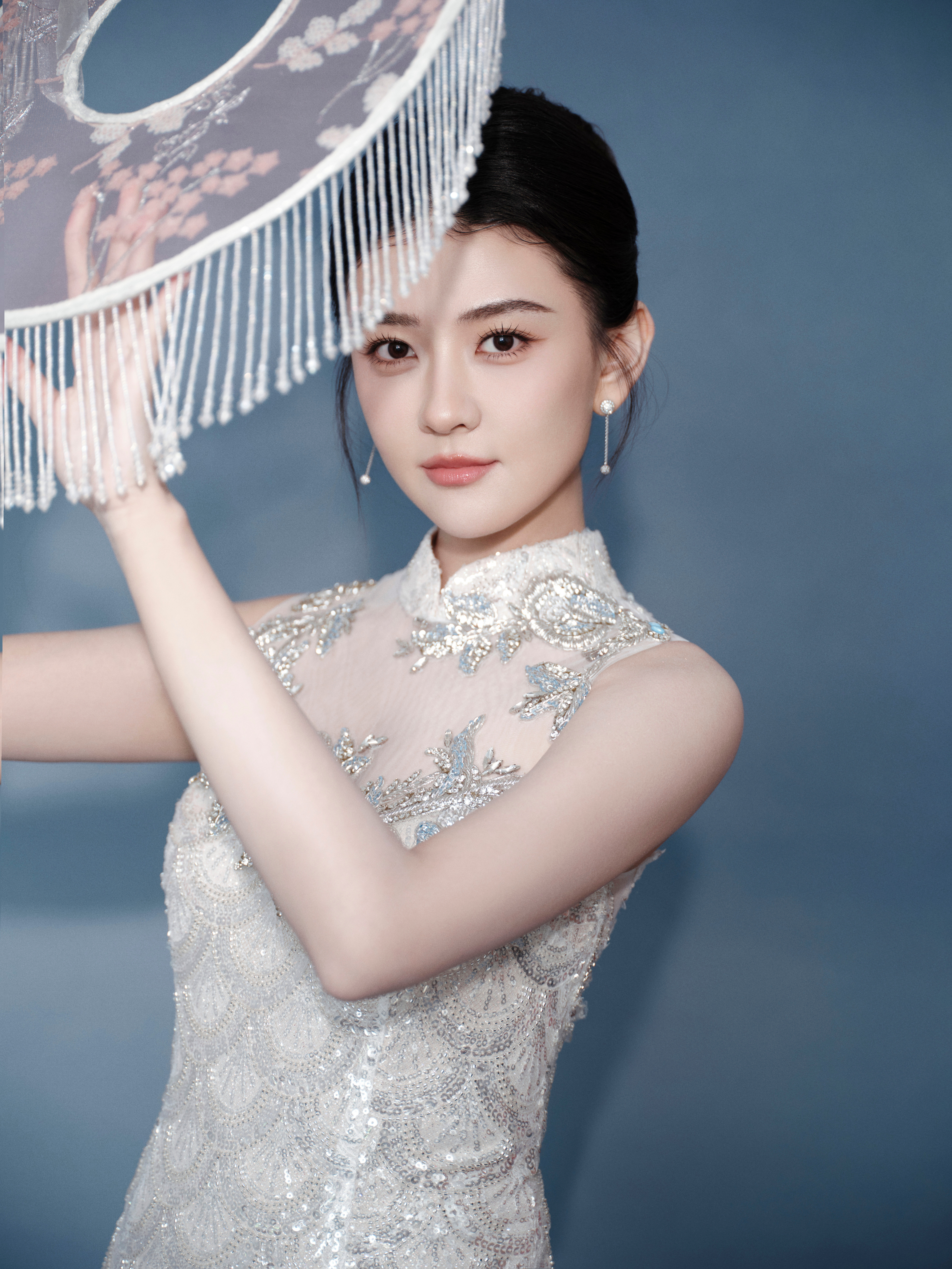 梁洁一袭银白亮片旗袍，勾勒窈窕身段， 立领添古典韵，透纱绣花藏诗意。东方美在光影
