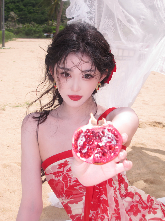 孔雪儿今天就像一簇娇艳欲滴红玫瑰奔赴海边解锁绝美氛围感造型，一身红色印花吊带长裙