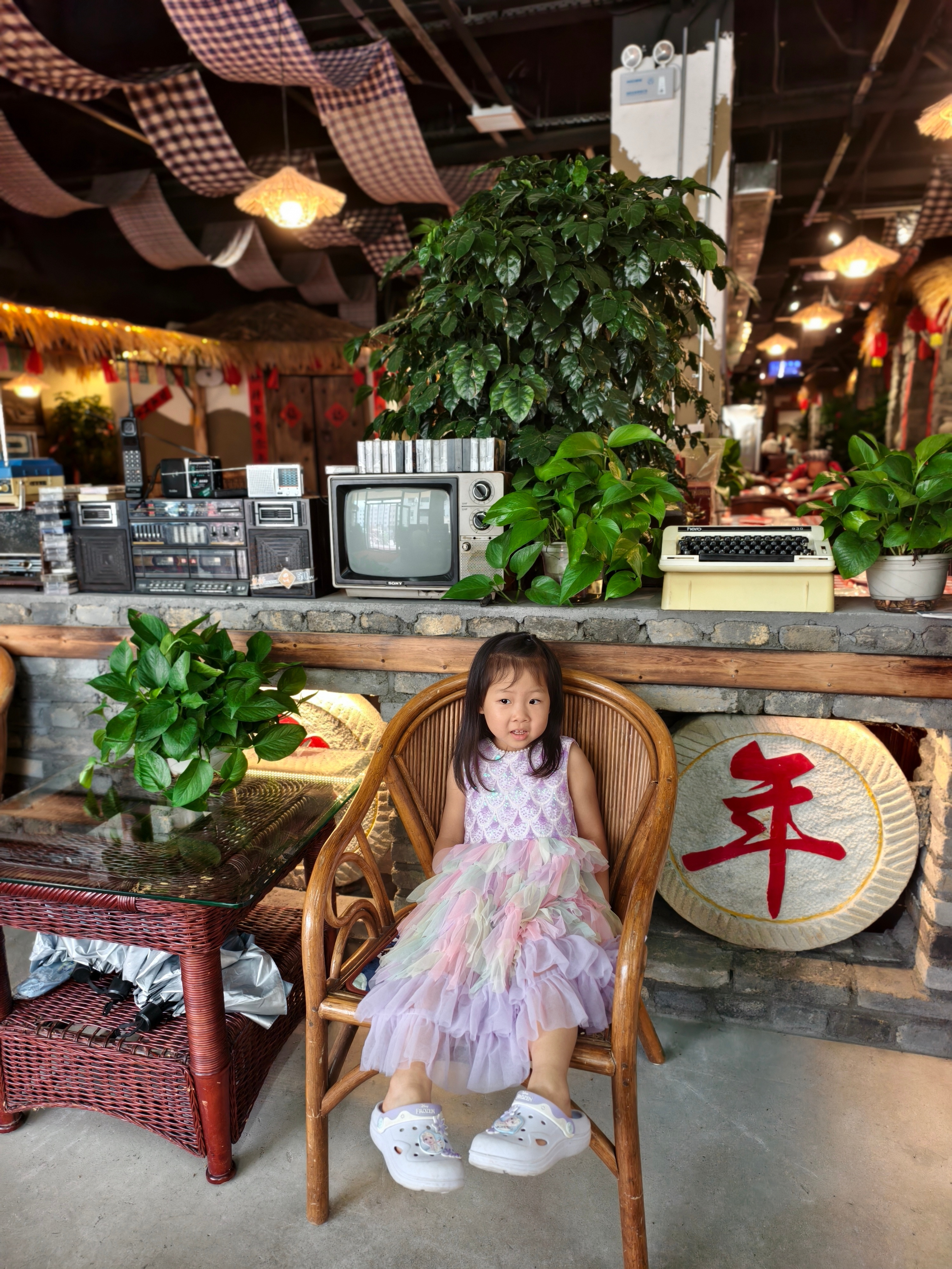 中午朋友请吃饭。饭店里摆了好多复古老物件，汤圆挺好奇的