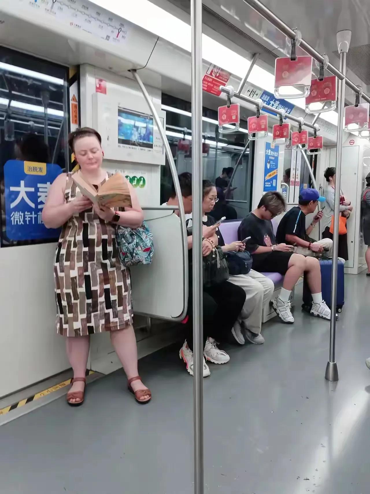 在湖南的一趟早班高峰的地铁车厢里，座位上的旅客大多数都是低头看手机的，唯独只看见