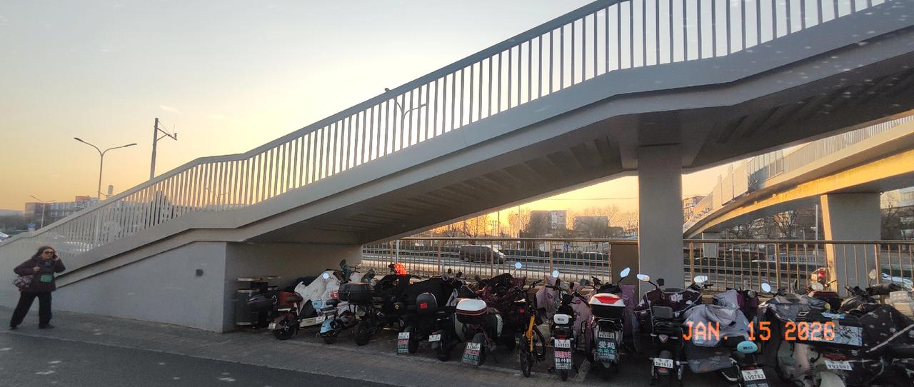 冬日北京平常的一个傍晚，天桥下的电动车正在等待主人下班归来，载着他们回到温暖的家