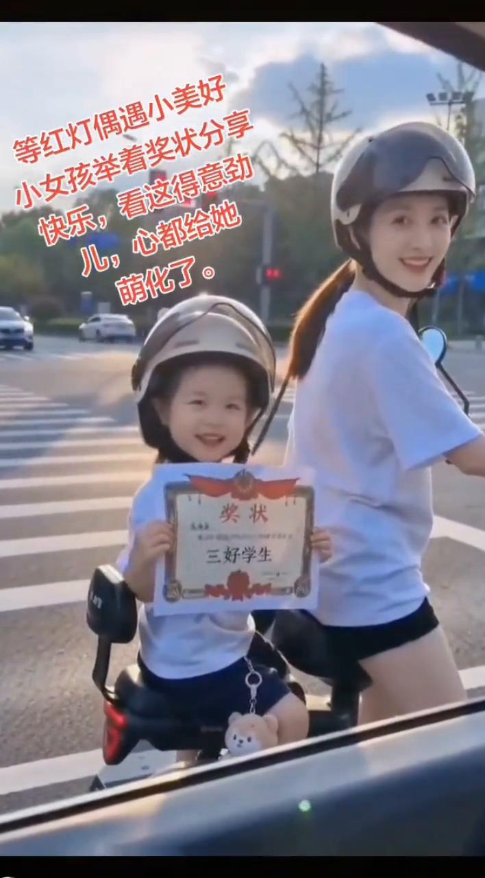 等红灯偶遇小美好，小女孩举着奖状分享快乐，看这得意劲。