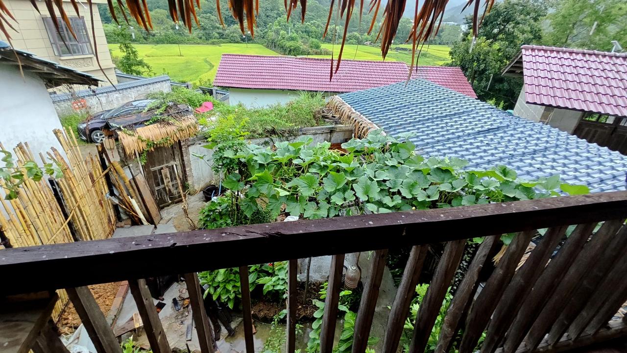 我山里小院阁楼上的风光
凭栏坐于小楼，
听雨落茅檐。
目之所及，
青山连绵，
稻