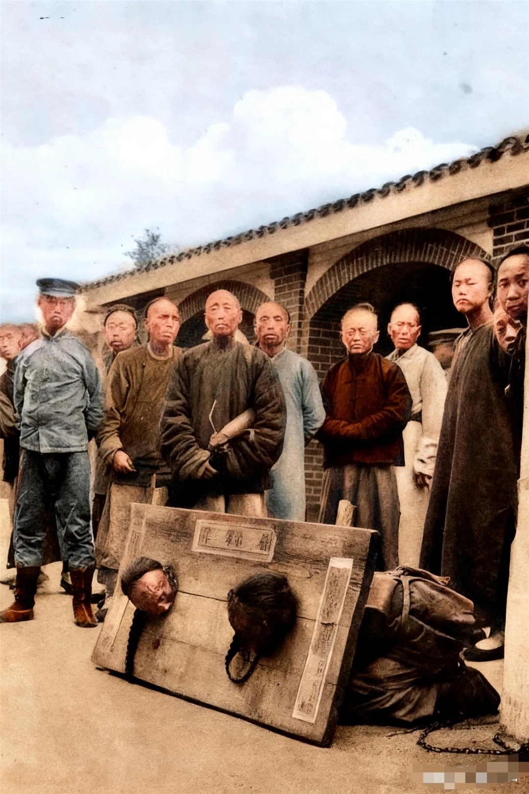 清末时期，两名在火车站前示众的囚犯。他们手臂被结结实实地反绑着，戴着同...
