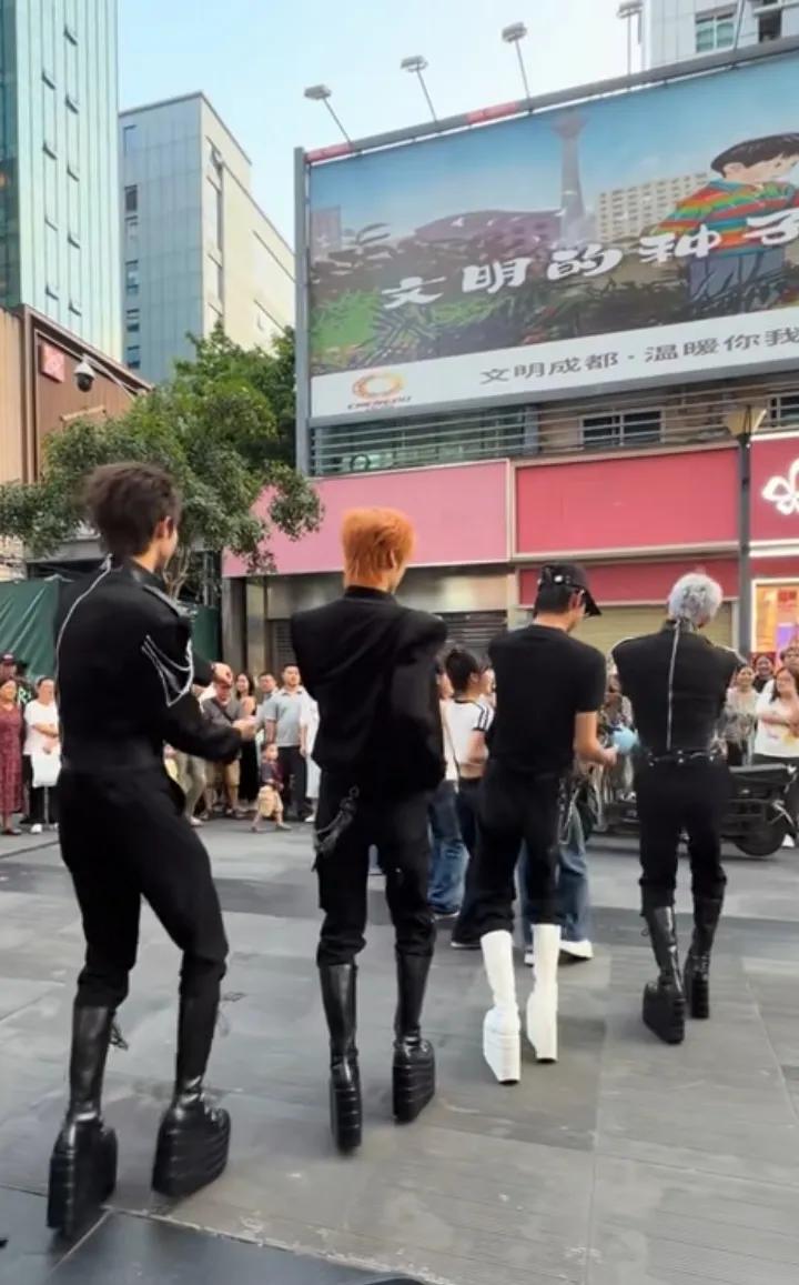 成都。
几名男孩在街边表演。穿着恨天高的鞋，头发五颜六色，绝对是一道亮丽的风景。