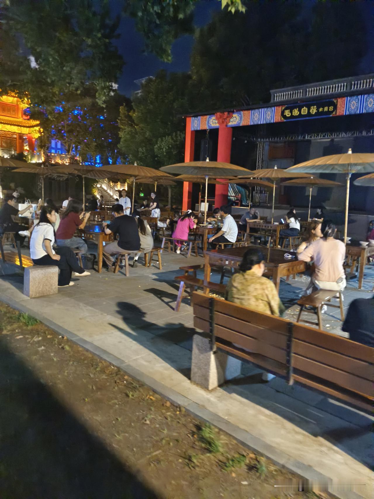 夜晚的公园里，人们享受着美食和聊天。公园治愈系美景 散步公园风景 公园休闲日常 
