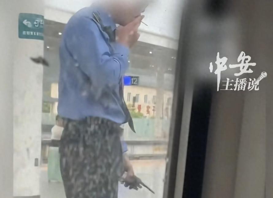当众吞云吐雾！4月29日列车停靠时，一名乘客拍下工作人员右手夹烟、左手握对讲机的