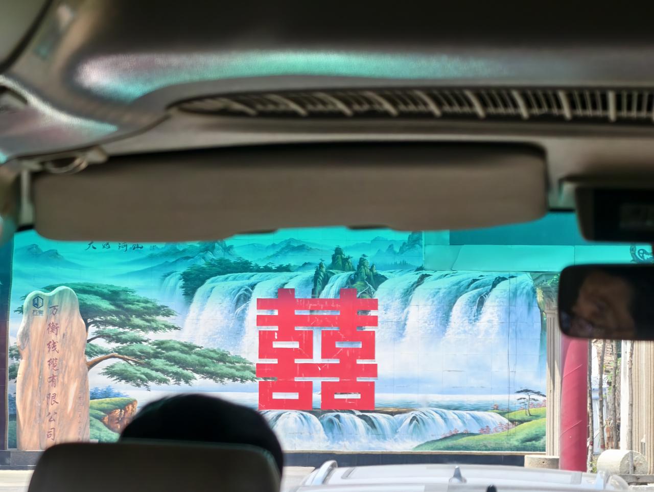 行车见囍，寻常藏烟火。
 
乘车隔窗望见影壁山水间大红囍字鲜亮夺目，中式喜庆融于