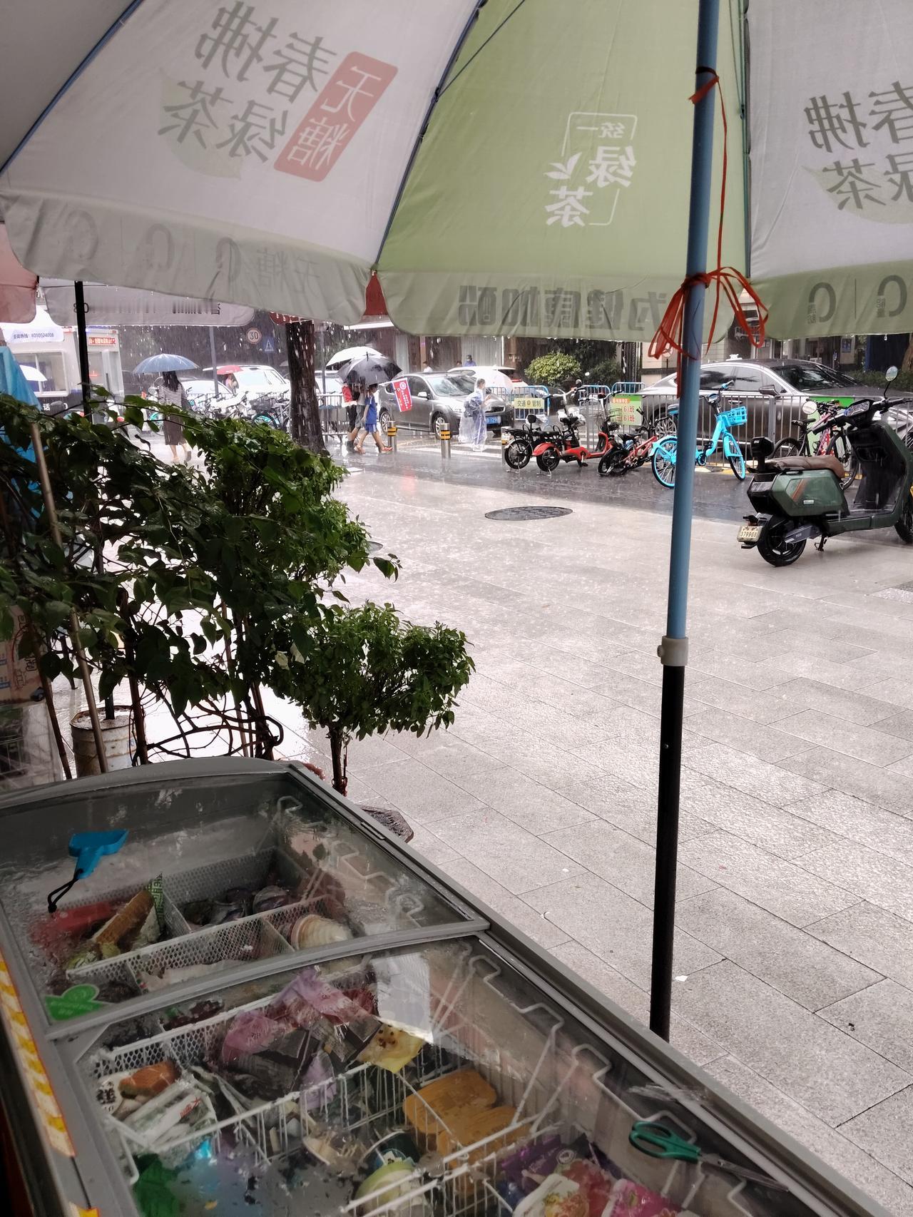 下雨天学校门口交通执勤的家长，成为一道风景线，雨越来越大，学校门口进出的人也越来