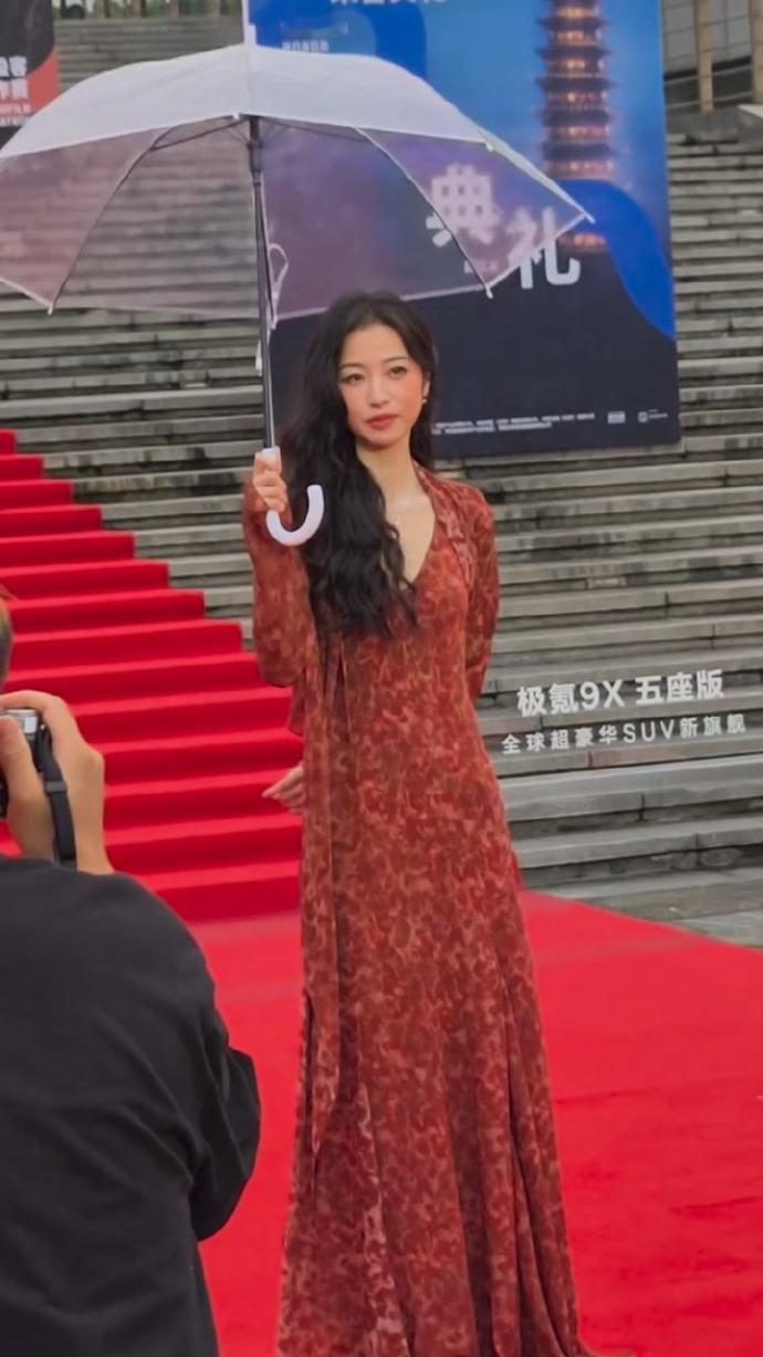 今天周雨彤在走红毯的时候搭配的非常漂亮，看上去也很有时尚风情，她打着伞的样子还很
