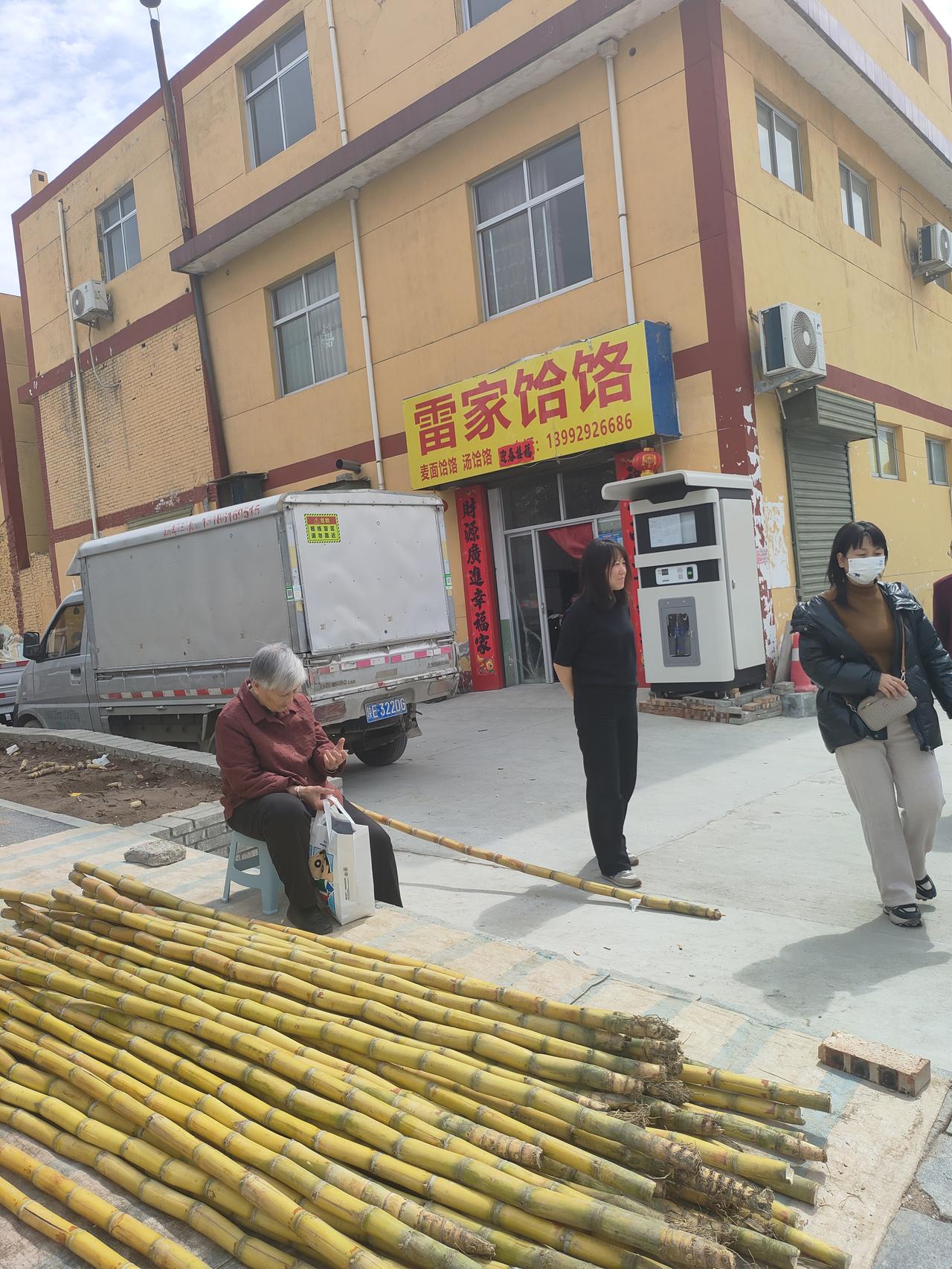 街边的甘蔗摊晒着暖融融的太阳，老人坐在小凳上挑着甜，面馆的红灯笼映着烟火气，春天