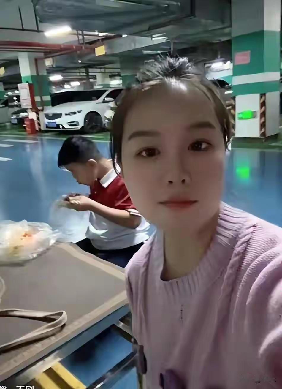 宝妈带娃在地下车库吃饭写作业，一位宝妈带着孩子，在车位边支小桌子，在这吃饭、写作