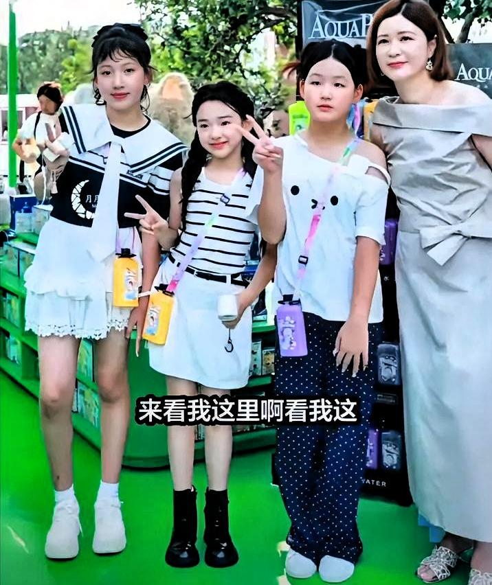 一群小孩拍照。小酒窝把别人往中间推，自己往后退。

退得特别自然，像练过很多次。