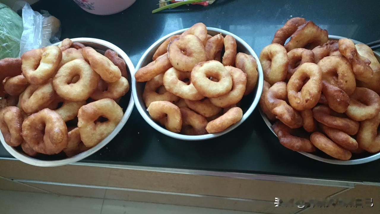 陕北婆姨腊月做的油馍馍，
那可是年茶饭里的一绝！
油馍馍看着圆滚滚、黄澄澄，
咬