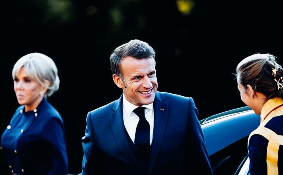 马克龙和妻子布丽吉特的表情形成了鲜明的反差啊！
马克龙和身边工作人员在热聊，满脸