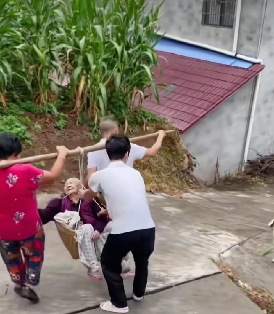 一对中年夫妻，抬着一个躺在箩筐里的白发老人，小心翼翼地走着，真实原因让人感动了，